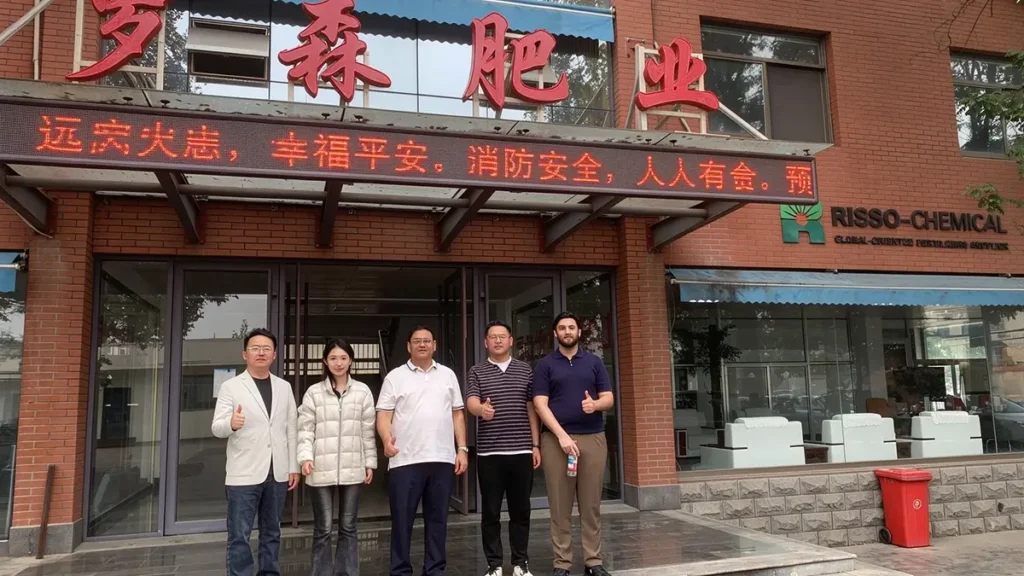 Pakistani customers visiting Risso Fertilizer and taking a group photo on the fertilizer production line in China.